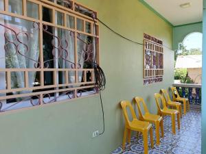 a row of yellow chairs lined up against a wall at Shine and Denden Transient House-Panglao in Panglao Island