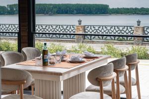a table with chairs around it with a view of the water at Danubius View - Luxury Hotel and Hall in Kozloduy
