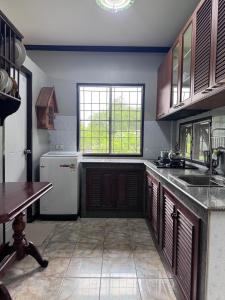 Una cocina con un refrigerador blanco y una ventana. en บ้านสวนอยุธยาคลองสระบัว, en Phra Nakhon Si Ayutthaya 14 fotos más