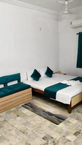 a bedroom with two beds with green pillows at Hotel Hirawat by Vihasta 