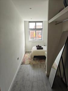 a white bedroom with a bed and a window at Newly Furnished Modern 1 bedroom City Apartment in Leicester