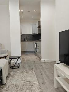 a living room with a television and a kitchen at Newly Furnished Modern 1 bedroom City Apartment in Leicester