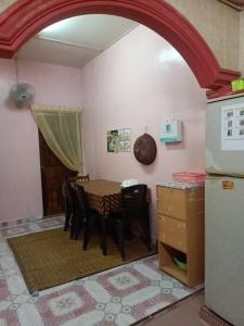 a kitchen with a table and chairs in a room at TMS Homestay in Kangar