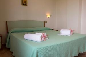 a bedroom with two beds with towels on them at residenceduemari in Capo Vaticano