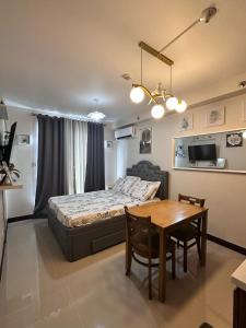 a bedroom with a bed and a dining room table at J&A Arcadia in Lapu Lapu City
