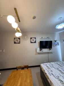 a bedroom with a bed and a flat screen tv at J&A Arcadia in Lapu Lapu City