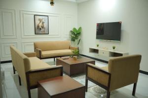 a living room with a couch and a tv at Qayaam Lodges in Islamabad