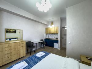 a bedroom with a bed and a desk and a table at Shirin And Cozy Apartment With Jacuzzi Balcony in Tbilisi City