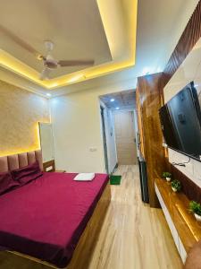 a room with a bed and a flat screen tv at The Azure1 in Greater Noida