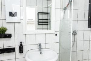 a bathroom with a sink and a mirror and a shower at CosyHomes24 - Spacious with TOP traffic connection - UN02b in Schwerte +13 photos