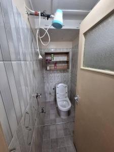 a bathroom with a toilet and a shower with a light at Two Bedroom Guest House in Nairobi