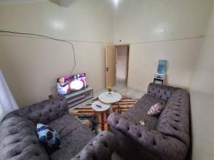 a living room with two couches and a tv at Two Bedroom Guest House in Nairobi