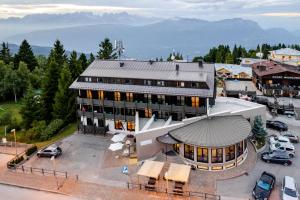 an aerial view of a building with a parking lot at Hotel Dolomiti Chalet in Vason