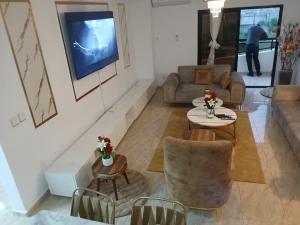 ein Wohnzimmer mit Sofa und Fernseher in der Unterkunft Residence KLYC1 Abidjan Cocody in Abidjan