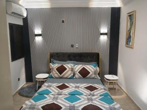 ein Schlafzimmer mit einem Bett mit zwei Hockern daneben in der Unterkunft Residence KLYC1 Abidjan Cocody in Abidjan