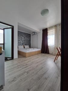 a bedroom with a bed and a wooden floor at StudioApartment LUXOR in Constanţa