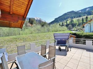 a patio with a table and chairs on a balcony at Apartment in Niedernsill near Ski Slopes in Niedernsill