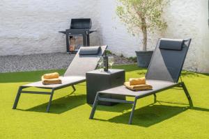 two chairs sitting on the grass with a table at Espaciosa casa a 15 min de Sendaviva y Bardenas in Cadreita