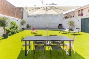 a table and chairs with an umbrella on a lawn at Espaciosa casa a 15 min de Sendaviva y Bardenas in Cadreita