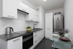 Una cocina blanca con fregadero y estufa. en Stylowy Apartament w Warszawie Sypialnia & Parking w Garażu by Noclegi Renters, en Varsovia