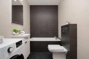 un baño con inodoro y lavabo en Stylowy Apartament w Warszawie Sypialnia & Parking w Garażu by Noclegi Renters, en Varsovia