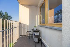 - Balcón con mesa y 2 taburetes en Stylowy Apartament w Warszawie Sypialnia & Parking w Garażu by Noclegi Renters, en Varsovia