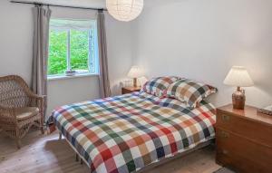 a bedroom with a bed and a chair and a window at Four Bedroom Nice Home In Gilleleje in Gilleleje