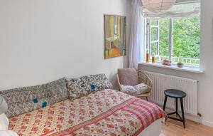 a bedroom with a bed and a chair and a window at Four Bedroom Nice Home In Gilleleje in Gilleleje
