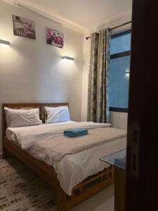 ダル・エス・サラームにあるElles Residenceのベッドルーム1室(窓、テーブル付)