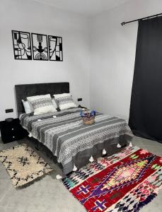 Un dormitorio con una cama y una alfombra en el suelo. en Mood Villa Essaouira, en Essaouira