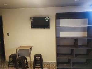 a room with a tv and a table and chairs at Hotel Cadiz IN in Ibagué