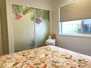 Un dormitorio con una cama con un estampado de flores en la pared. en Janet's home, en Pimpama