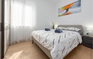 Un dormitorio blanco con una cama con almohadas azules. en 2 Bedroom Gorgeous Apartment In Zadar, en Zadar