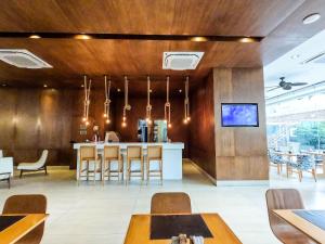 a restaurant with wooden walls and a bar with chairs at Estanconfor Praia Santos 3 - AC garagem arrumação sacada fechada in Santos