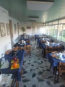a dining room with blue tables and chairs and windows at Albergo Calcagno in Borgio Verezzi