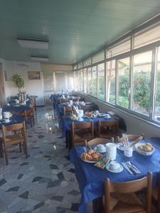 a dining room with blue tables and chairs with food on them at Albergo Calcagno in Borgio Verezzi