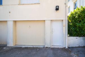 a white building with two garage doors on it at Studette Croisette, proche Martinez in Cannes
