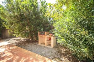 a small wooden table in a garden with trees at Casita Luisa in Crestatx
