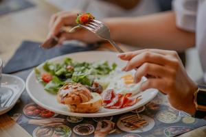 a person is eating a plate of breakfast food at Hotel Marina Club in Olsztyn