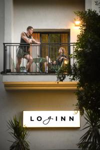 zwei Personen auf einem Balkon eines Gebäudes in der Unterkunft Pixel Hotel - Rooftop & Spa in Tel Aviv