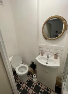a bathroom with a toilet and a sink and a mirror at Entire Cosy Flat in Central London in London