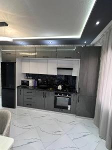a kitchen with gray cabinets and a white tile floor at Heart of Samarkand, main center in Samarkand
