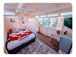 Un dormitorio con una cama con flores rojas. en Ariba española, en Santo Domingo
