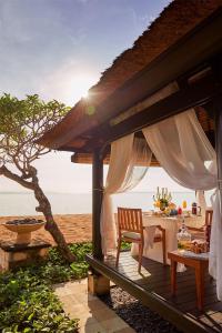un patio con tavolo e sedie sulla spiaggia di Conrad Bali a Nusa Dua