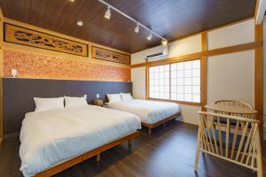 a bedroom with two beds and a window at Nagashima Onsen Villa Kuwana ,Family & Group Stay with Private Onsen in Kuwana +78 photos