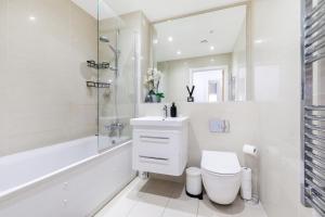 a white bathroom with a toilet and a sink at Amazing apartment in Surrey - On street Parking in Whyteleafe