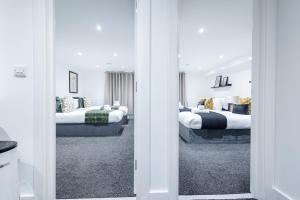 two beds in a room with two beds at Sunrise Haven Sleeps 7 with Parking in Gravesend +8 photos