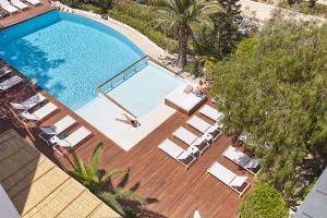 una vista aérea de una piscina con tumbonas en Apartamentos Castaví, en Es Pujols