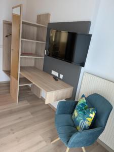 a living room with a tv and a chair at Gasthaus Linde Ingelfingen in Ingelfingen
