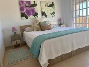 a bedroom with a large bed with flowers on the wall at Apartamentos The Heights - Los Cristianos in Los Cristianos